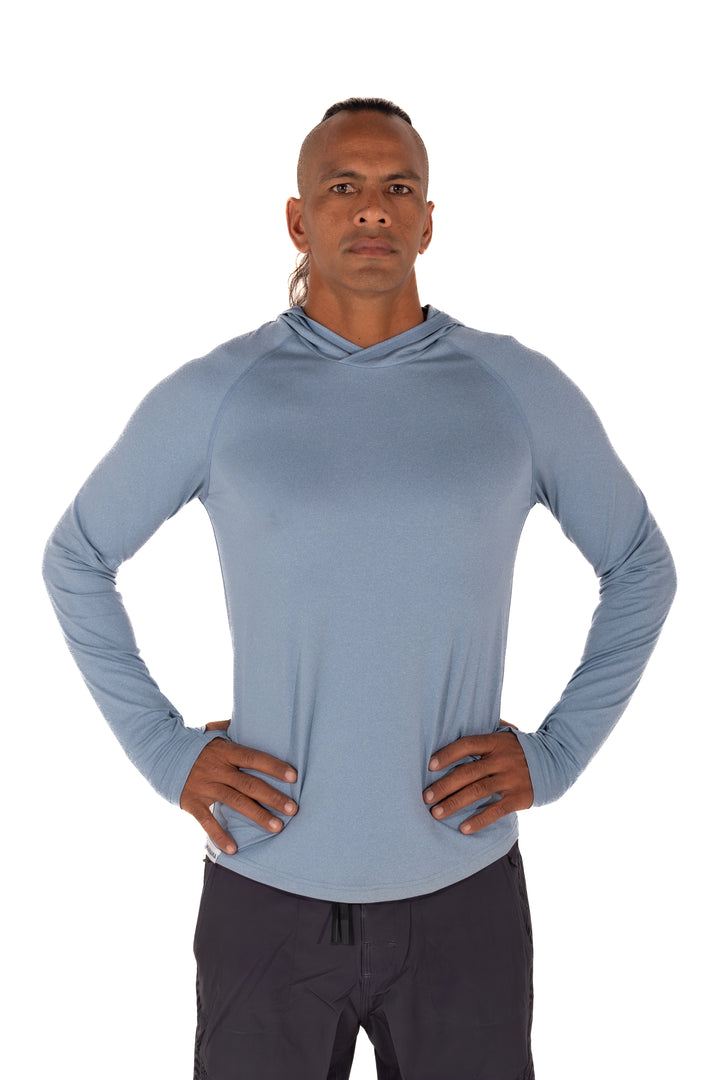 Male model wearing the Waihana Mariner Blue Hooded Long Sleeve sun shirt, a fitted light blue UPF hoodie, posed with hands on hips against a white background.